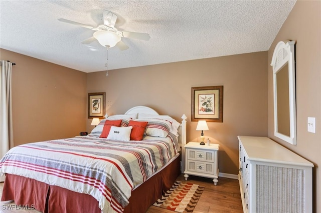 bedroom featuring ceiling fan, a textured ceiling, and hardwood / wood-style flooring