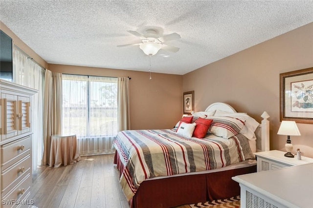 bedroom featuring a textured ceiling, light hardwood / wood-style flooring, and ceiling fan