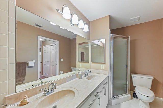 bathroom with toilet, vanity, tile patterned floors, and a shower with door