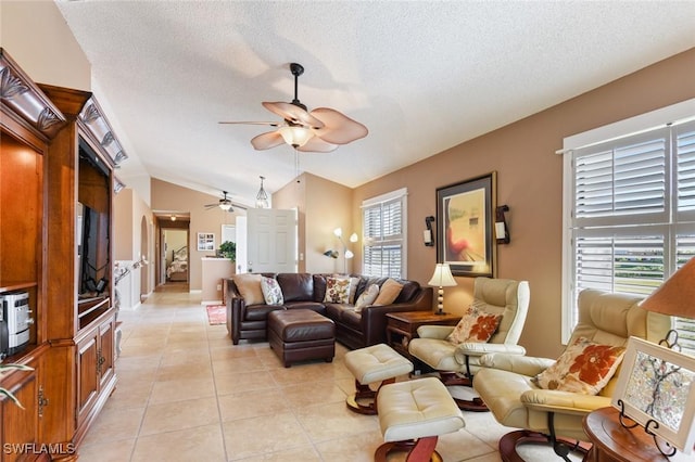 living room with a textured ceiling, ceiling fan, light tile patterned flooring, and vaulted ceiling