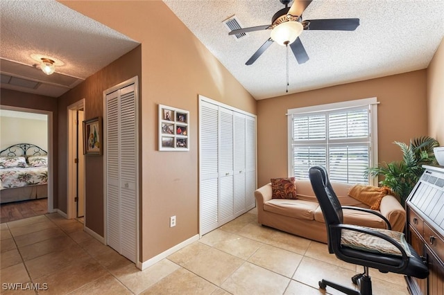 tiled office featuring vaulted ceiling, ceiling fan, and a textured ceiling