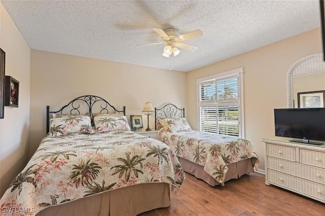 bedroom with ceiling fan, a textured ceiling, and hardwood / wood-style flooring