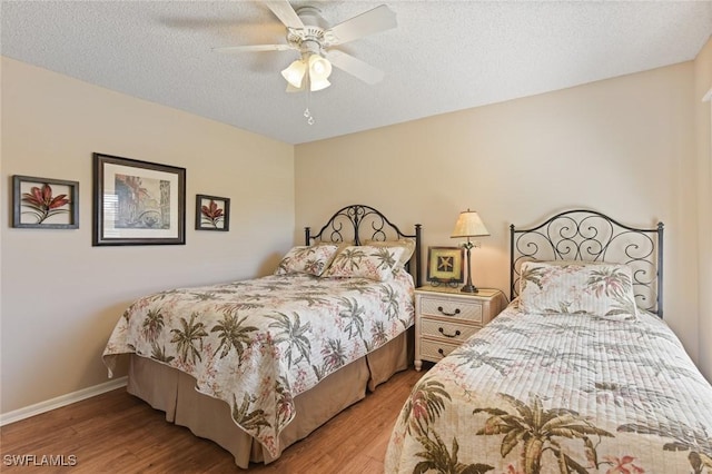 bedroom with ceiling fan, light hardwood / wood-style flooring, and a textured ceiling