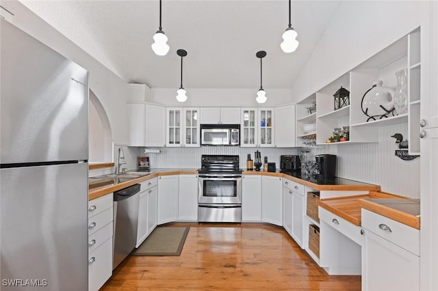 kitchen featuring decorative light fixtures, white cabinetry, sink, and appliances with stainless steel finishes