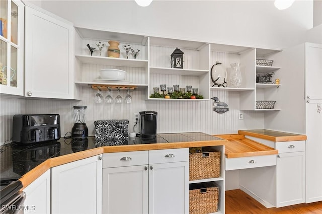 kitchen featuring white cabinets, stove, light hardwood / wood-style floors, and tile counters