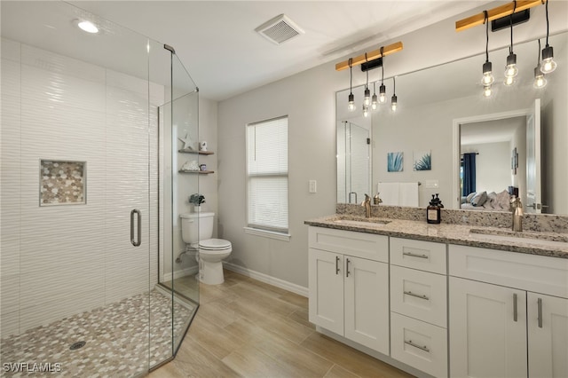 bathroom with hardwood / wood-style floors, toilet, an enclosed shower, and vanity