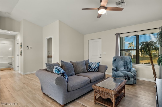 living room featuring ceiling fan, light hardwood / wood-style floors, and lofted ceiling