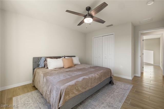 bedroom featuring a closet, light hardwood / wood-style flooring, and ceiling fan