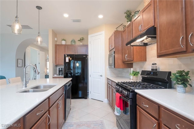 kitchen with sink, backsplash, decorative light fixtures, light tile patterned floors, and black appliances