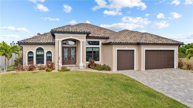 mediterranean / spanish-style house featuring french doors, a front lawn, and a garage