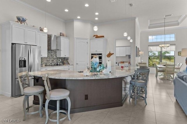 kitchen featuring white cabinets, appliances with stainless steel finishes, and a large island with sink