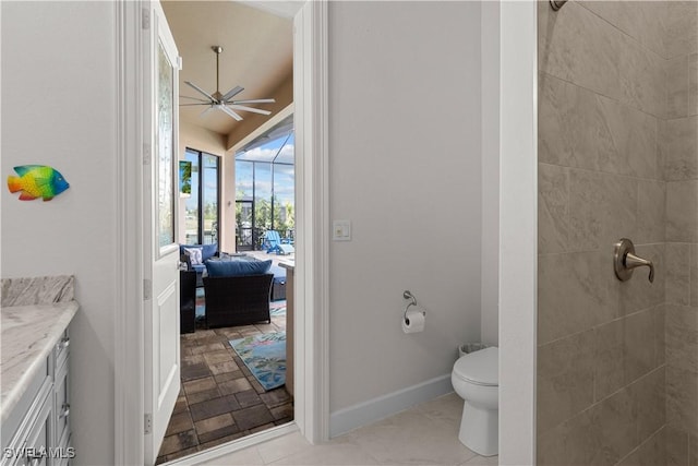 bathroom with tiled shower, vanity, toilet, and ceiling fan