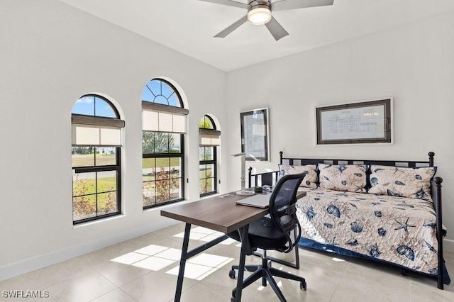 tiled home office featuring ceiling fan