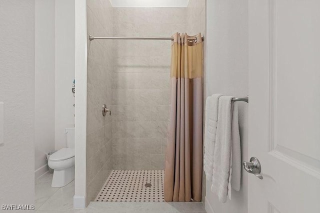 bathroom featuring a shower with shower curtain, tile patterned flooring, and toilet