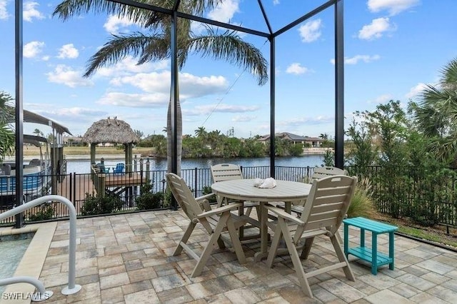 view of patio featuring a lanai and a water view