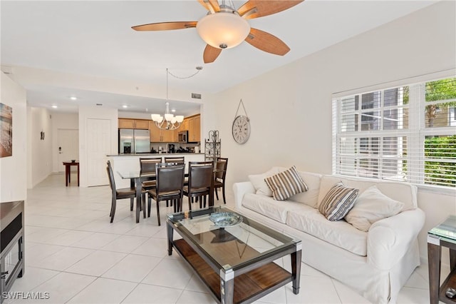 living room featuring ceiling fan with notable chandelier and light tile patterned floors