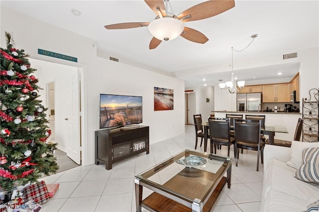 tiled living room featuring ceiling fan with notable chandelier