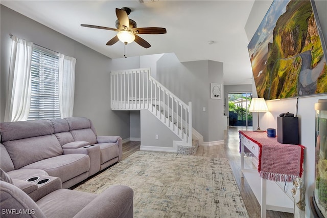 living room featuring light hardwood / wood-style flooring and ceiling fan