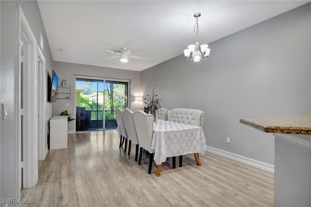 dining area with ceiling fan with notable chandelier and light hardwood / wood-style flooring