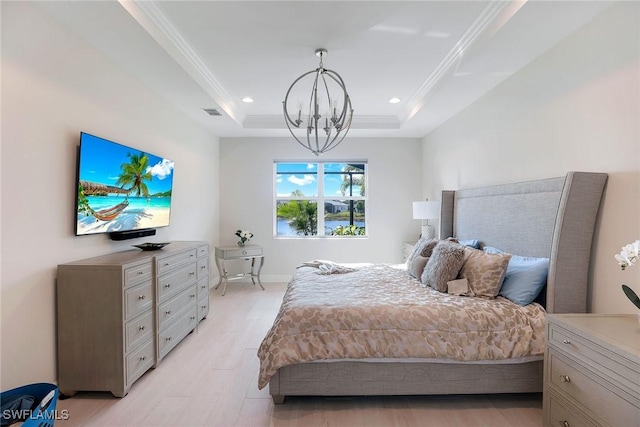 bedroom with light wood-type flooring, a tray ceiling, an inviting chandelier, and crown molding