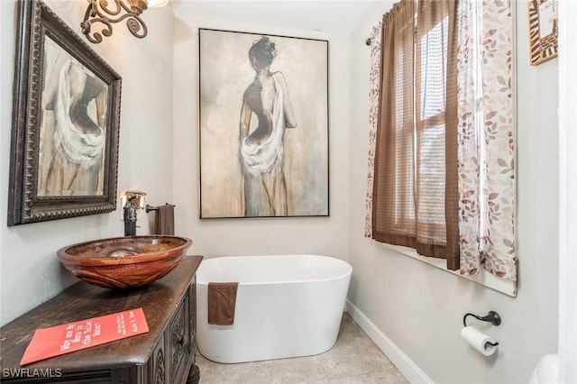 bathroom with tile patterned floors, a tub, and sink