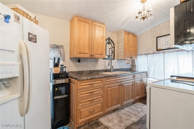 kitchen with white fridge with ice dispenser, sink, a notable chandelier, decorative backsplash, and range