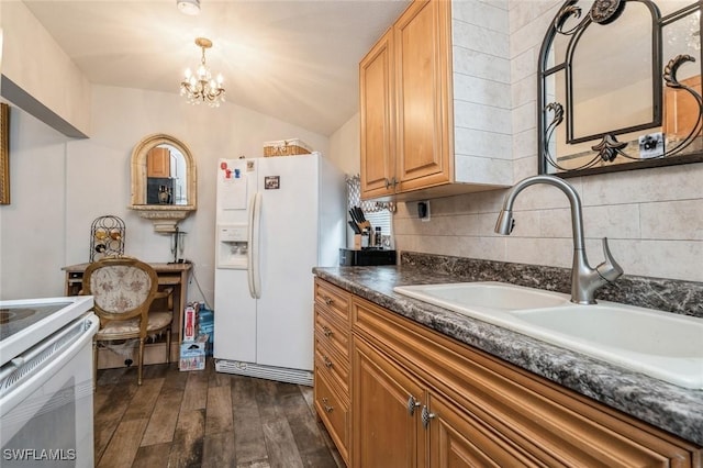 kitchen featuring white appliances, lofted ceiling, sink, a notable chandelier, and dark hardwood / wood-style flooring