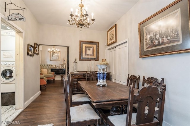 dining space featuring dark hardwood / wood-style flooring, stacked washer and dryer, and an inviting chandelier