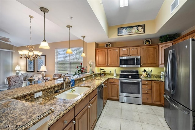 kitchen with sink, stainless steel appliances, an inviting chandelier, dark stone counters, and pendant lighting