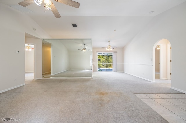 carpeted empty room featuring vaulted ceiling and ceiling fan