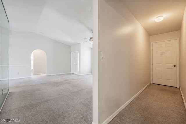 hallway featuring light carpet and lofted ceiling