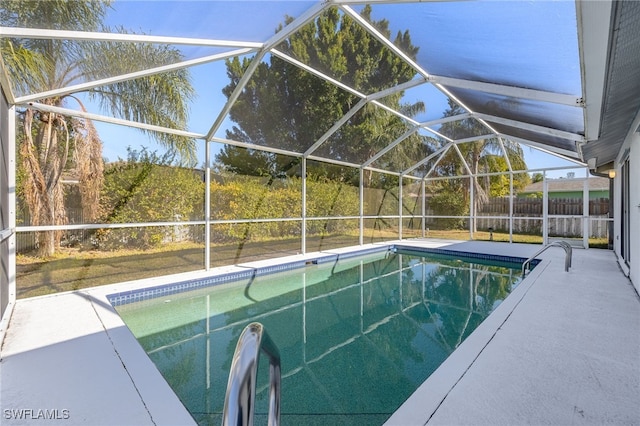 view of swimming pool with glass enclosure and a patio area