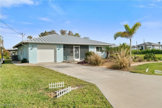 ranch-style home featuring central air condition unit, a front yard, and a garage