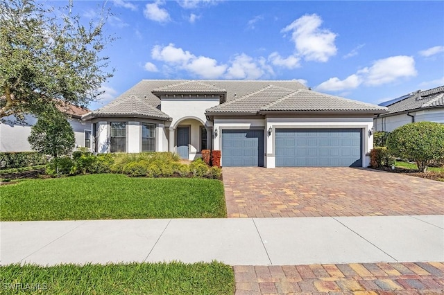 mediterranean / spanish house featuring a garage and a front lawn