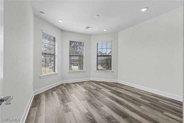 spare room with wood-type flooring and a wealth of natural light