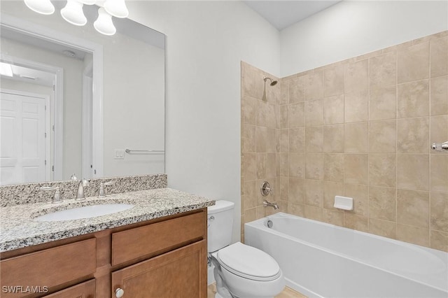 full bathroom with vanity, tiled shower / bath combo, and toilet