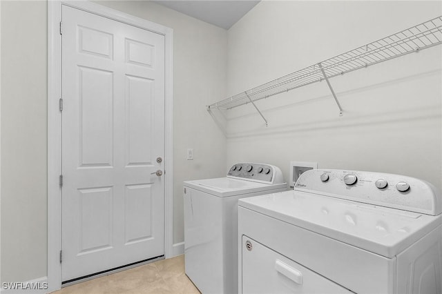 laundry area featuring light tile patterned floors and washing machine and clothes dryer