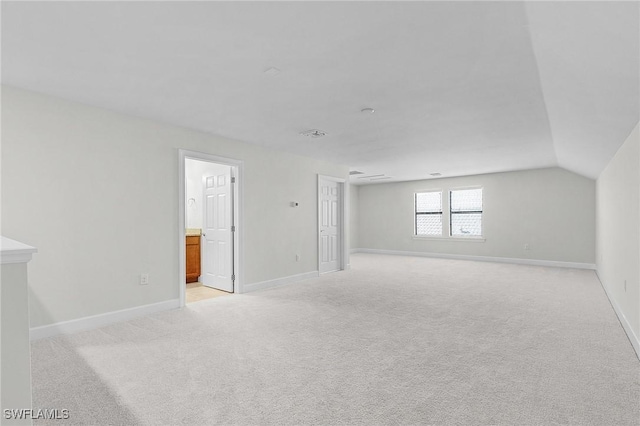 carpeted spare room with vaulted ceiling