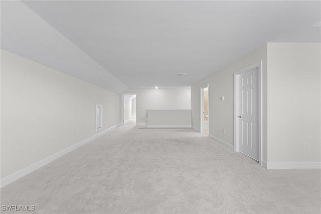 unfurnished room with light carpet and vaulted ceiling