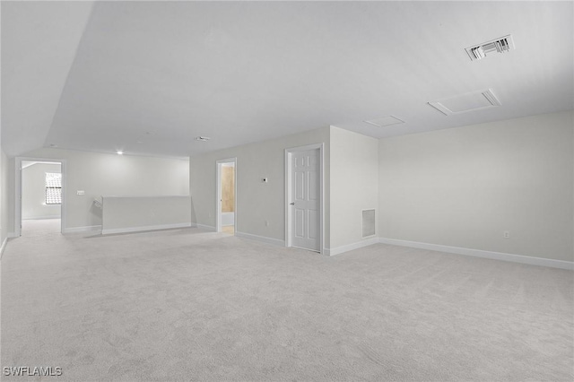 unfurnished room featuring light colored carpet and vaulted ceiling