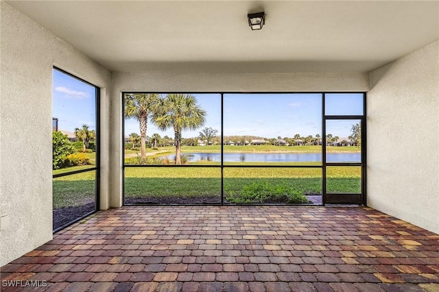 unfurnished sunroom with a water view