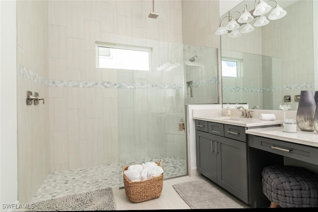 bathroom with tiled shower, vanity, tile patterned floors, and a healthy amount of sunlight