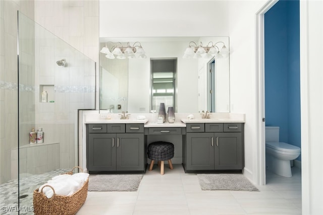 bathroom with tiled shower, tile patterned floors, vanity, and toilet