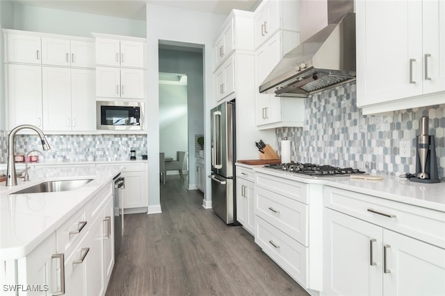 kitchen with white cabinetry, sink, wall chimney exhaust hood, dark wood-type flooring, and stainless steel appliances