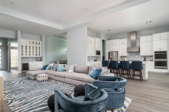 living room featuring beverage cooler and light wood-type flooring