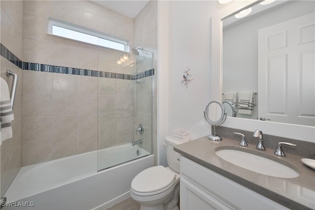 full bathroom with toilet, vanity, and tiled shower / bath