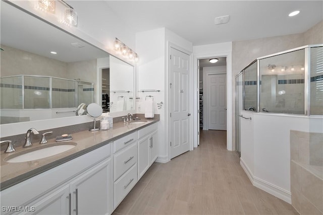 bathroom featuring vanity, wood-type flooring, and an enclosed shower