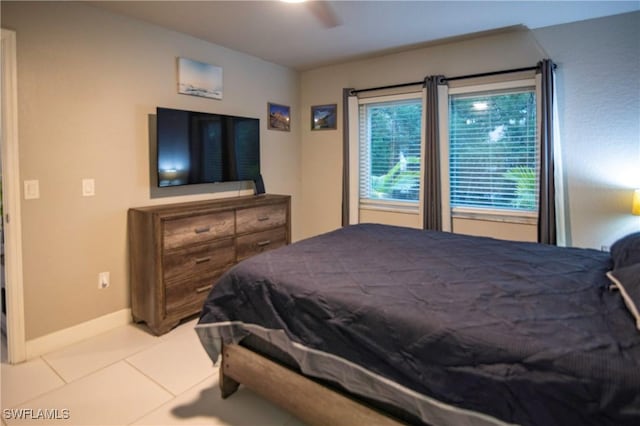 tiled bedroom featuring ceiling fan