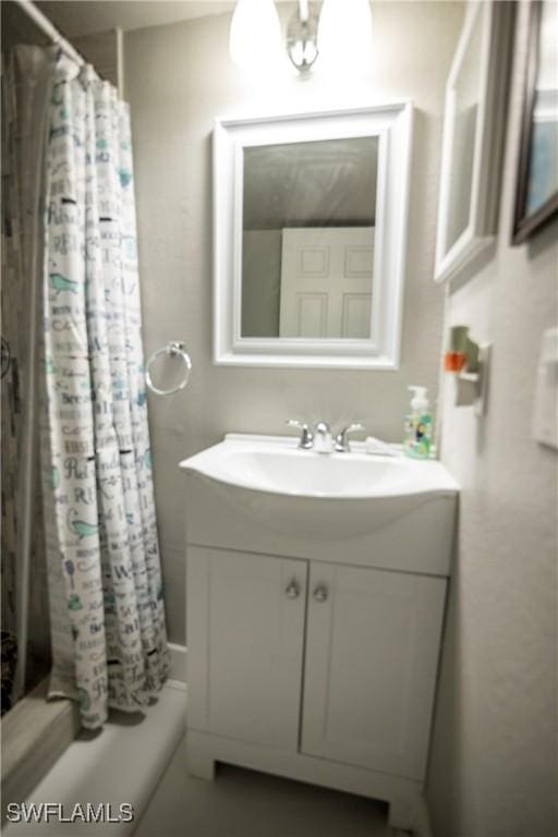 bathroom featuring shower / tub combo and vanity