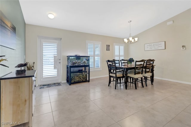 dining room featuring light tile patterned floors, vaulted ceiling, and an inviting chandelier